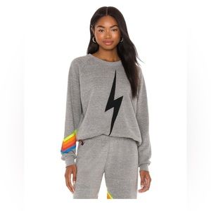 Gray aviator nation crewneck, black lighting bolt in middle and neon stripes